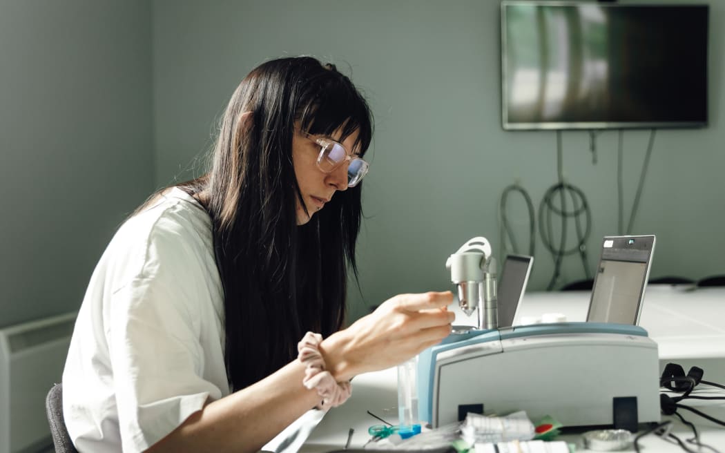 A technician using equipment to carry out a drug check, at the NZ Drug Foundation clinic.
