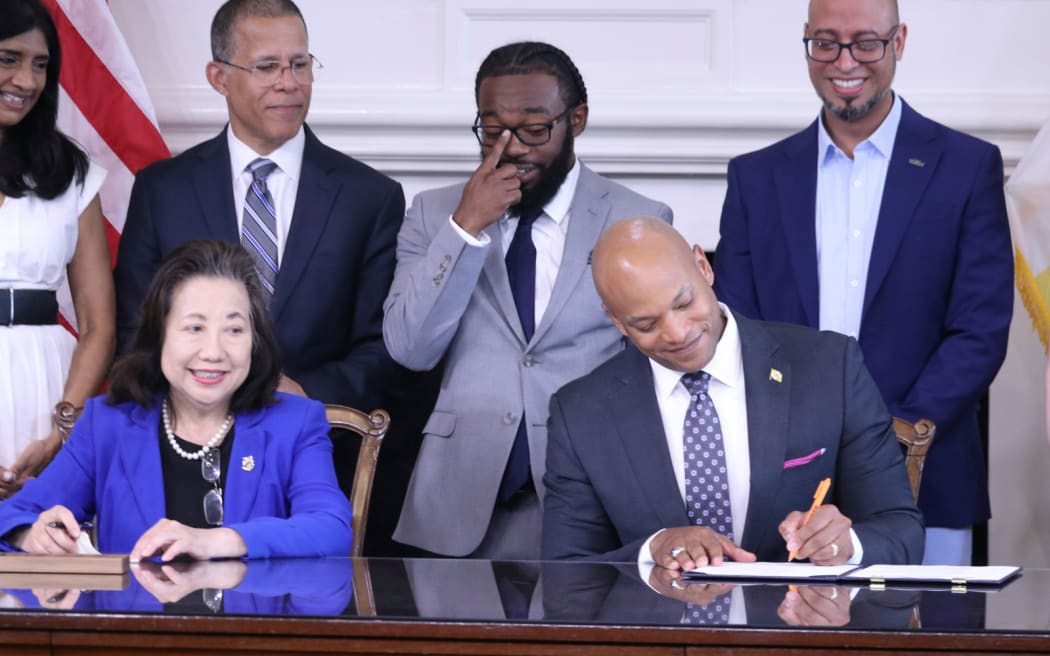 Maryland Gov. Wes Moore signs an executive order to issue more than 175,000 pardons for marijuana convictions on Monday, June 17, 2024 in Annapolis, Md. Maryland Secretary of State Susan Lee is seated left. Standing left to right are Lt. Gov. Aruna Miller, Maryland Attorney General Anthony Brown, Shiloh Jordan, Jason Ortiz, director of strategic initiatives for Last Prisoner Project and Heather Warnken, executive director of the University of Baltimore School of Law Center for Criminal Justice. (AP Phopto/Brian Witte)