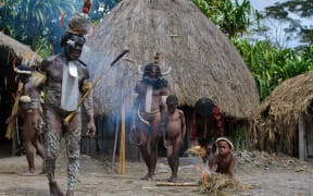 Papuans in traditional garb in their village