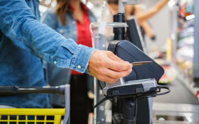 Man paying with NFC in a grocery store.