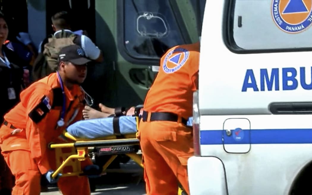 Grab taken from Panamanian channel TVN Noticias showing Panamanian paramedics carrying one of the 15 people rescued from a religious sect on a stretcher in Santiago, Veraguas province, Panama on January 15, 2020.