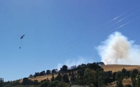 A helicopter is seen fighting a fire in Christchurch's Port Hills.