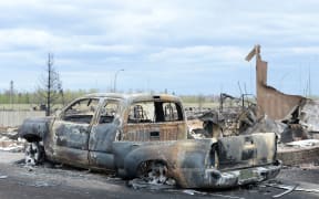 A burned out truck and the remains of a house in the Beacon Hill neighbourhood of Fort McMurray.