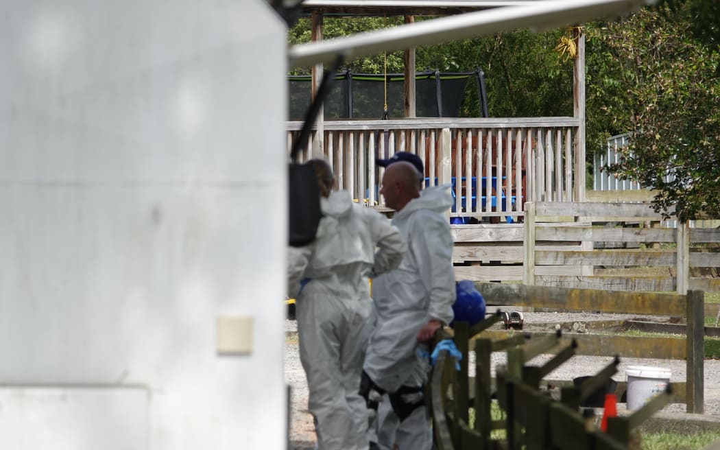 Police remain at the scene of the fatal Sanson house fire on Tuesday.