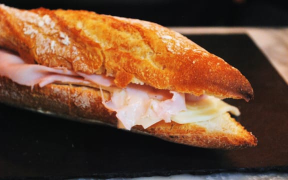 A baguette stuffed with ham and cheese