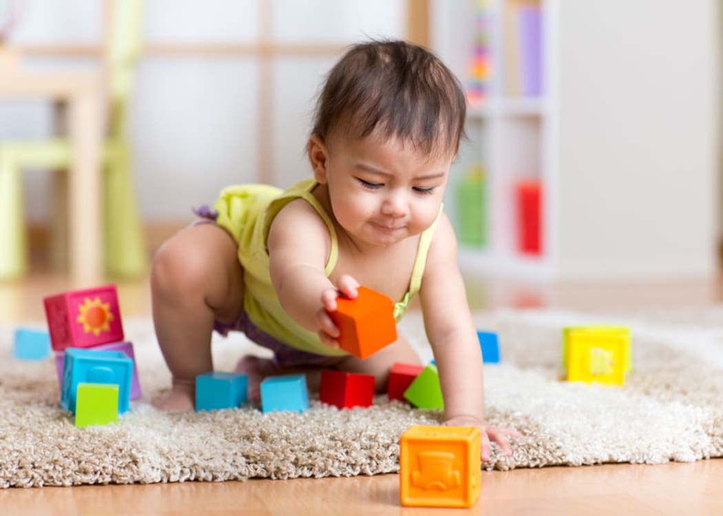 A photo of a toddler playing with blocks