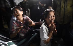 Family members celebrate while camping out near Tham Luang cave following news all members of children's football team and their coach were alive in the cave.