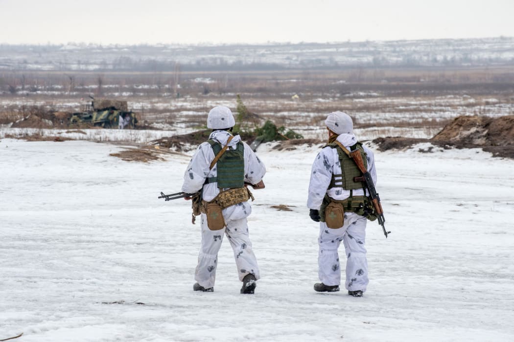 Ukrainian soldiers walk in a field during  live-fire exercises in Chuguev, Kharkiv region on February 10, 2022. (Photo by Sergey BOBOK / AFP)