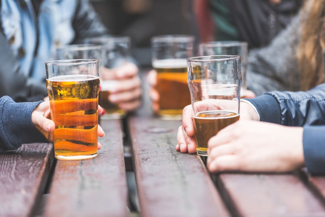 A group of friends drink beer at a bar.
