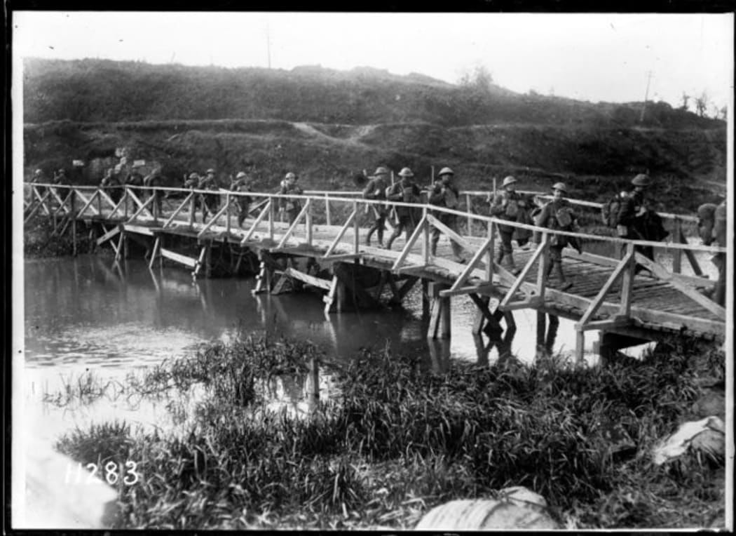 New Zealand soldiers walking over a wooden bridge spanning the Ypres Canal heading for the firing line at the Western Front on18 October 1917