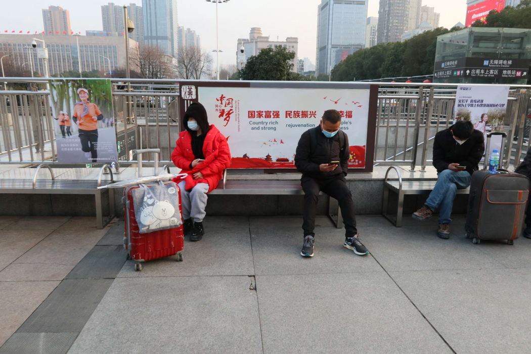 People wearing masks are seen near Hankou Railway station in Wuhan City, Hubei Province, China on February 5, 2021. The station is located about 1km from Huanan seafood market where many people were infected in the new coronavirus Covid-19 pandemic in early 2020.