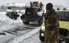 Civil defence and military vehicles clear snow from a central street of Aringo near Montereale in Italy after the earthquakes.