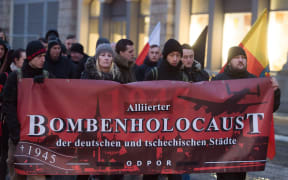 Right-wing extremists hold up a banner reading 'Alliierter Bombenholocaust' (lit. 'Allied Bombing Holocaust') during a so-called funeral march in Dresden on 11 February 2017.