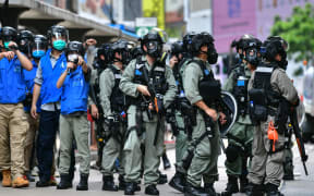 Riot police gather on a road as protesters take part in a pro-democracy rally