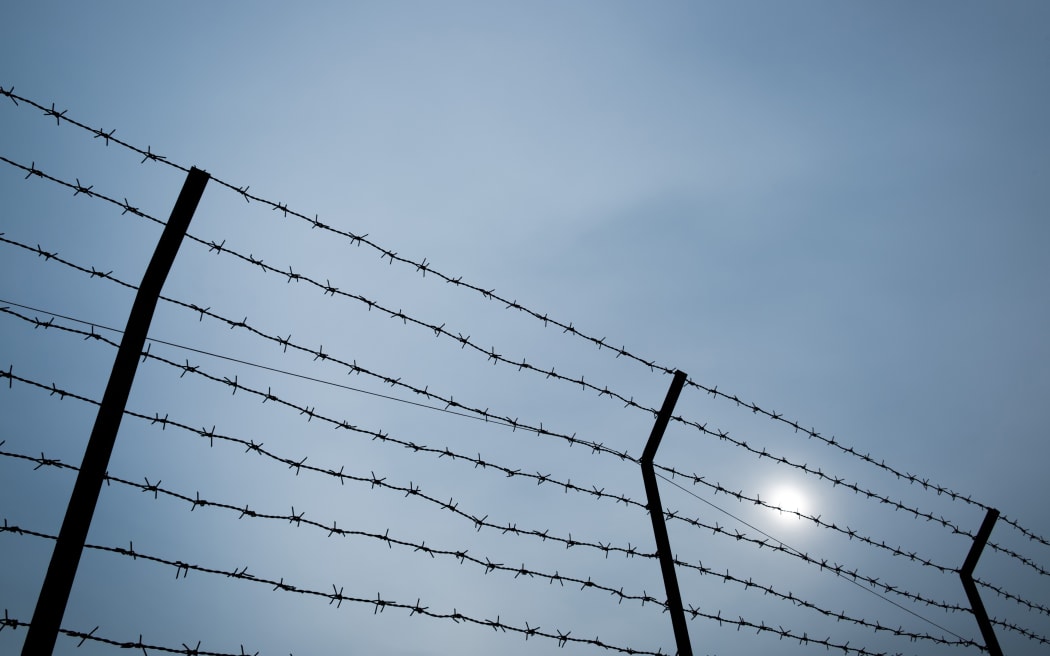 Silhouette of barbed wire on the fence of detention center.