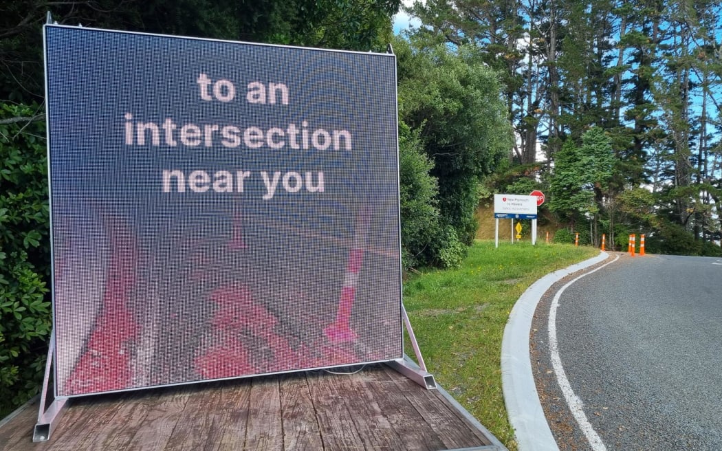 Mystery surrounds tongue in cheek digital billboard placed by an intersection where Waka Kotahi has recently finished work. Junction Road and State Highway 3.