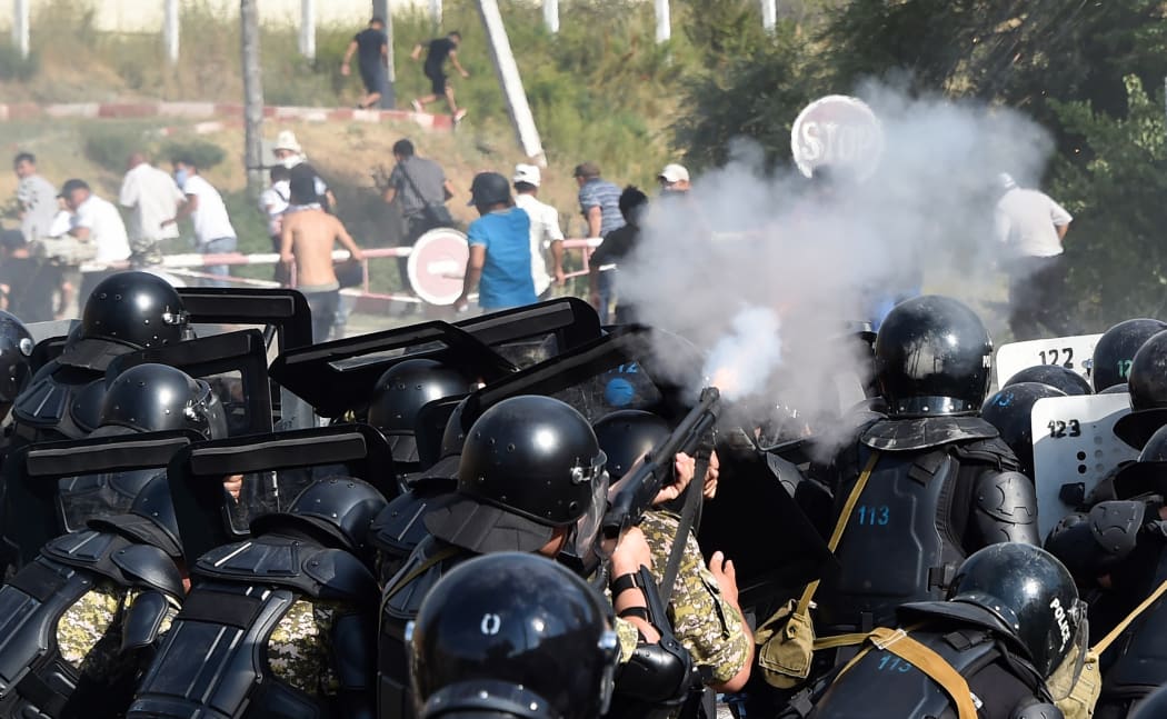 Kyrgyz special forces fire weapons as they block a street during clashes between supporters of Kyrgyzstan's former president and law enforcement, in the village of Koy-Tash.