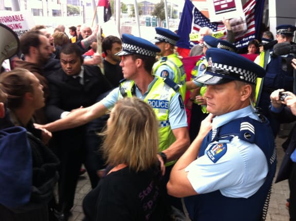 Protesters and police clash outside the meeting.