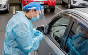 A health worker conducts a test at a COVID-19 coronavirus testing centre in the suburb of Northcote in Auckland on August 12, 2020.