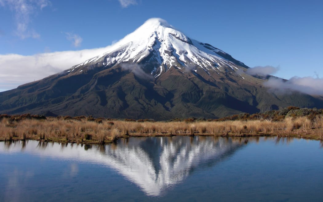 A view of Mt Taranaki over a waterway.