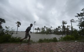 A boy runs along an embankment ahead of the expected landfall of cyclone Amphan, in Dacope, Bangladesh, on 20 May 2020.