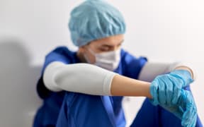 medicine, healthcare and pandemic concept - sad young female doctor or nurse wearing face protective mask for protection from virus disease sitting on floor at hospital