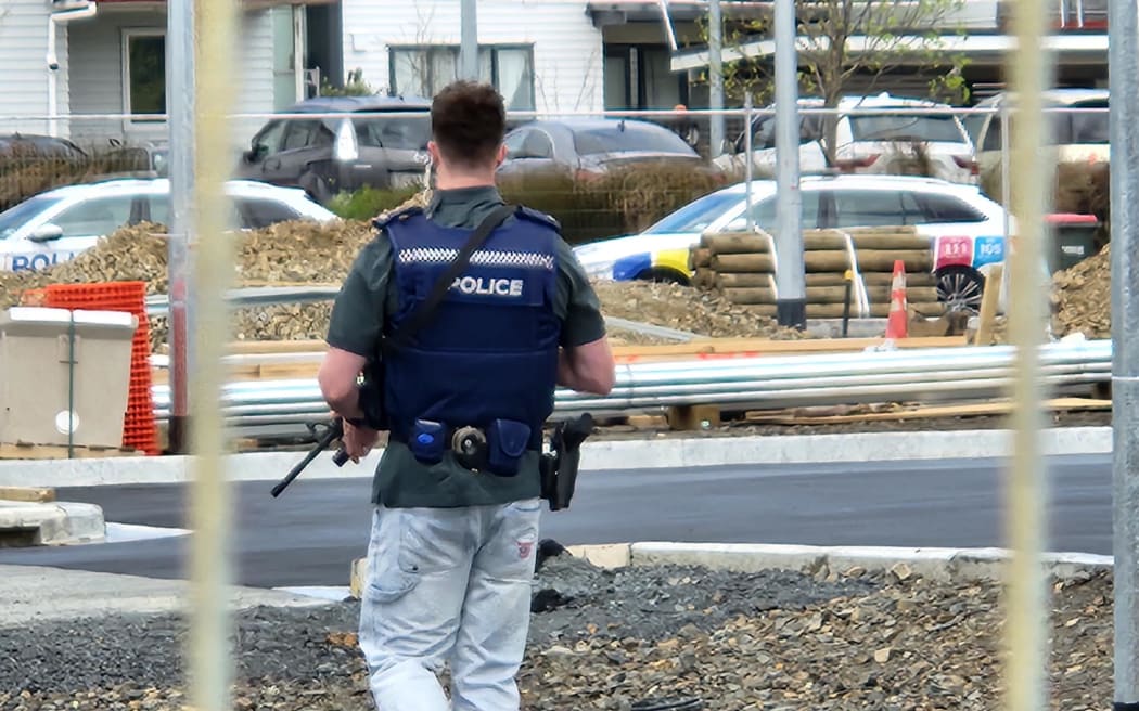 An armed police officer at the scene of a shooting in Flat Bush, Auckland.