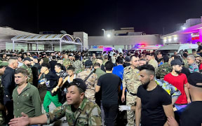 Soldiers, emergency responders and other helpers at the Hamdaniyah hospital gather around ambulances carrying wounded people after a fire broke out during a wedding in Al-Hamdaniyah, Iraq, on 27 September.