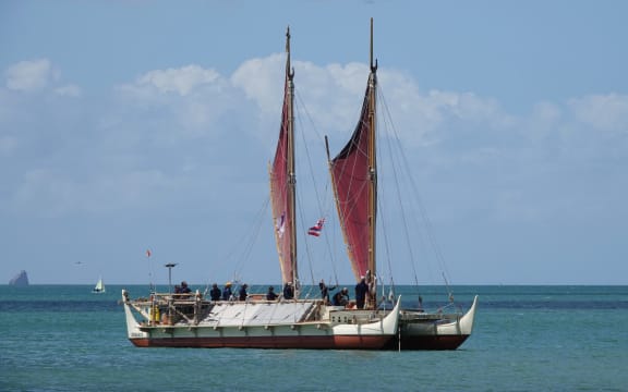 The wa’a (waka) Hōkūle’a anchors in Tii Bay.