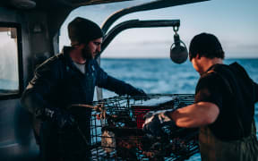 Two people working on a Tora Collective boat.