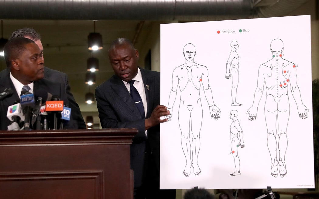 Attorney Ben Crump holds a diagram showing gunshot wounds to Stephon Clark