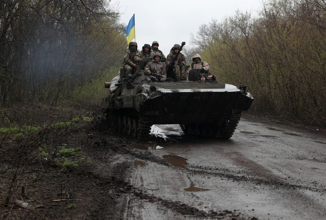 Ukrainian soldiers stand on an armoured personnel carrier (APC), not far from the front-line with Russian troops, in Izyum district, Kharkiv region.