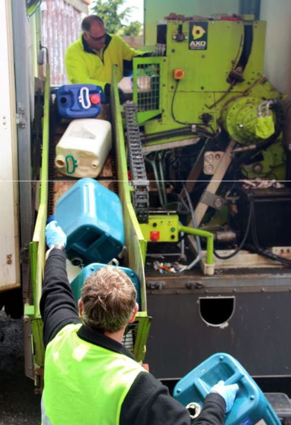 Feeding containers being put in the Agrecovery mobile processing truck.
