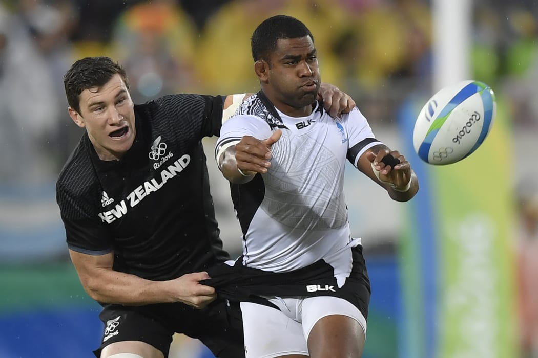 New Zealand's Sam Dickson, left, tackles Fiji's Vatemo Ravouvou in the men’s rugby sevens quarter-final match between Fiji and New Zealand at the Rio Olympics.