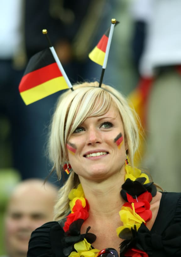 German football fan with face paint and flags