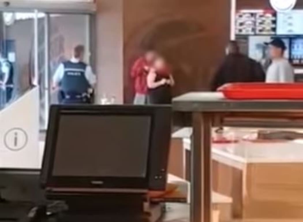Police spent almost 40 minutes negotiating with a man who held a knife to the throat of a woman he did not know in a mall in South Auckland this morning.