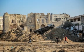 People walk in front of Gaza City's 17th century Qasr al-Basha or the Pasha's Palace on January 5, 2024, also known as Radwan dynasty castle, which houses a museum and a girls school, damaged in Israeli bombardment during the ongoing battles between Israel and the Palestinian Hamas movement. The conflict triggered by Hamas's deadly October 7 attack on Israel has caused massive destruction in the Gaza Strip, killing tens of thousands and leaving residents on the brink of famine. Much of the territory has become unrecognisable, as entire neighbourhoods which were once bustling with people, cars and donkey-drawn carts have been reduced to rubble. (Photo by AFP)