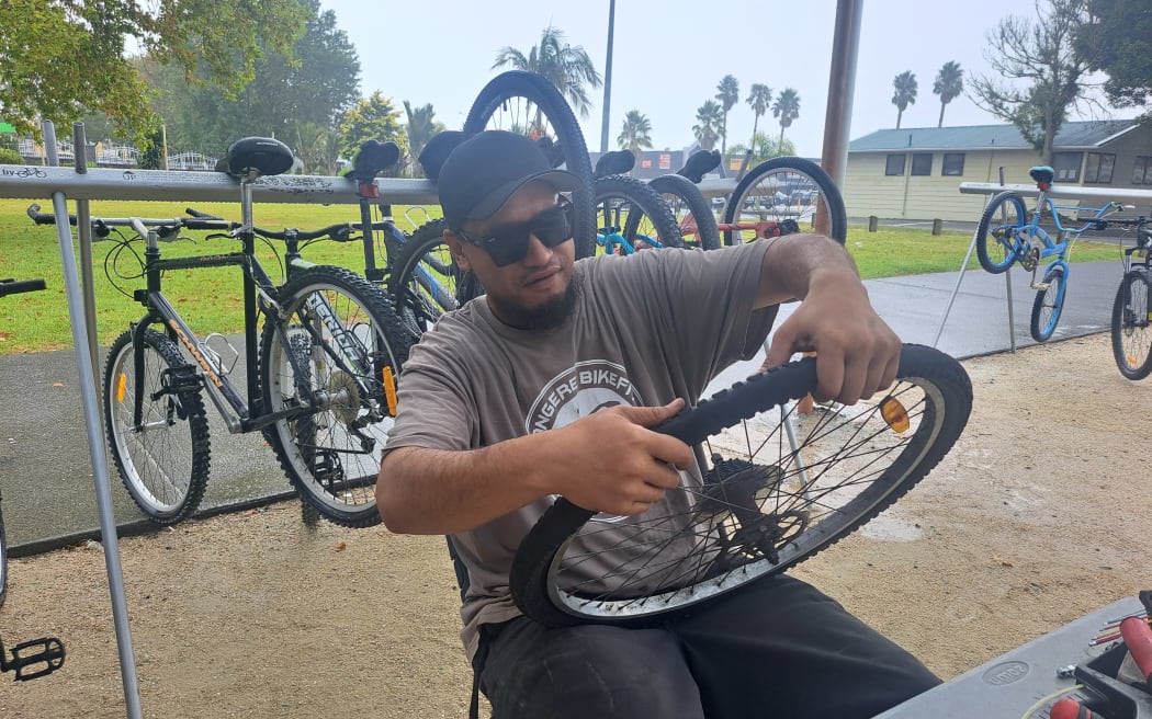 Worker Simon Setephano-Parekura, fixing a tyre at the Mangere BikeFit Community hub.
