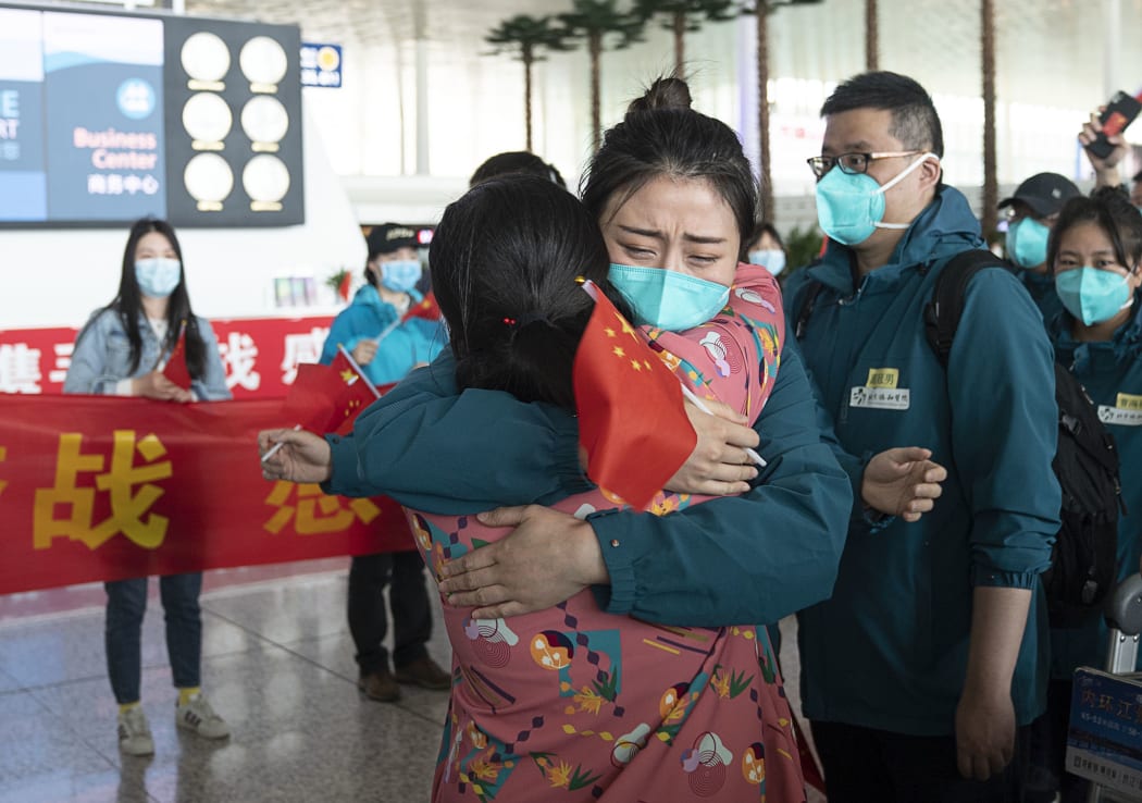 A medical worker from the Peking Union Medical College Hospital bids farewell to a local medical worker at the Wuhan Tianhe International Airport in Wuhan, capital of central China's Hubei Province, April 15, 2020.