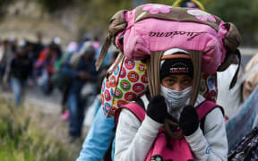A Venezuelan migrant woman heading to Peru walks along the Pan American highway in Tulcan, Ecuador, after crossing from Colombia, 21 August 2018.
