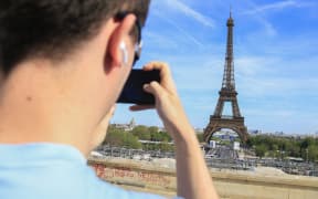 A tourist takes a photo with his phone of the Eiffel Tower in Paris on April 13, 2024.
Un touriste prend en photo avec son telephone la Tour Eiffel a Paris le 13 avril 2024. (Photo by Quentin De Groeve / Hans Lucas via AFP)