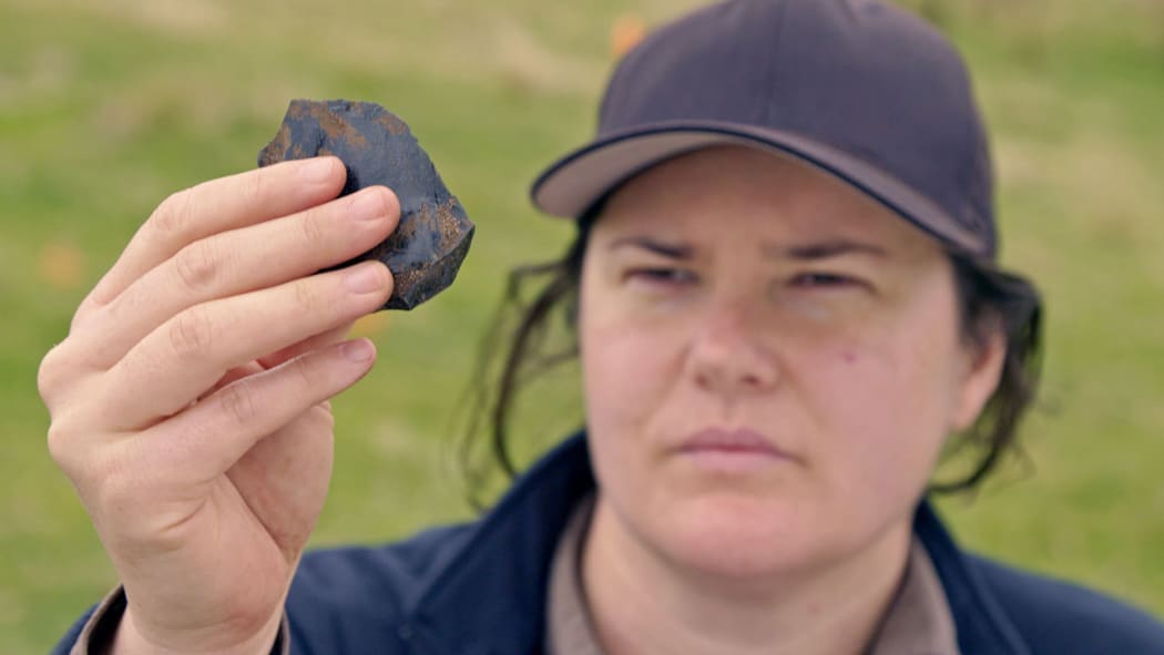 No captionUniversity of Auckland archaeologist Dr Rebecca Phillipps examining a stone artefact from Ahuahu/Great Mercury Island, during an University-led field research project.