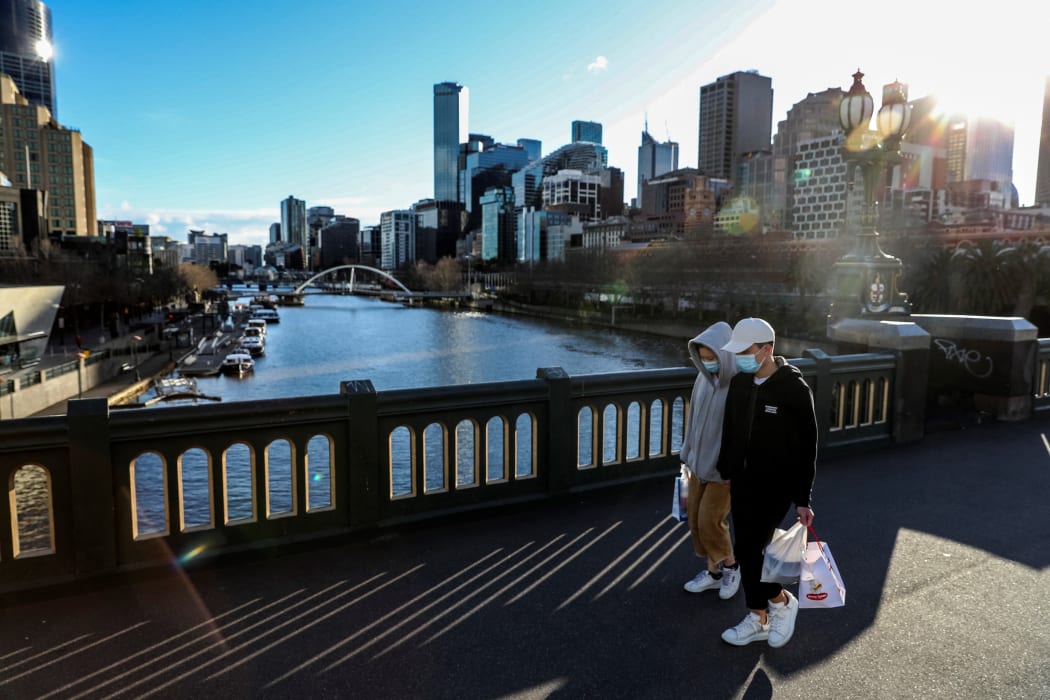 Pedestrians wearing face masks walk through Melbourne's Southbank on 16 July 2021, following a fresh Covid-19 lockdown.