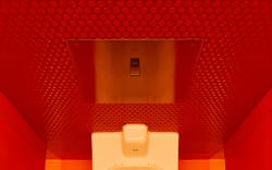 A toilet in a bright bathroom.