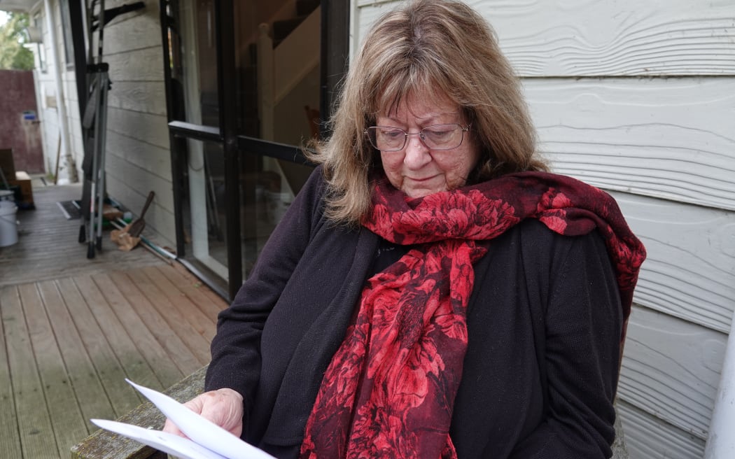 Christine Toms looks over the provisional report into her husband's death.