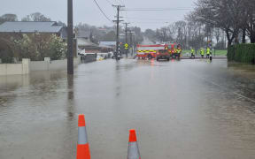 Firefighters use pumps to remove water from the flooded Ardwick Street in Gore on 21 September 2023.