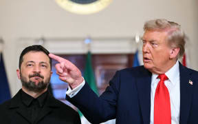 (L/R) Ukrainian President Volodymyr Zelensky and US President Donald Trump stand for a family photo with other European leaders in the Cross Hall of the White House in Washington, DC, on August 18, 2025. European leaders join Ukrainian President Volodymyr Zelensky in talks with US President Donald Trump on August 18, as they try to find a way to end Russia's offensive.  The leaders heading to Washington on Monday to appear alongside Zelensky call themselves the "coalition of the willing." (Photo by ANDREW CABALLERO-REYNOLDS / AFP)