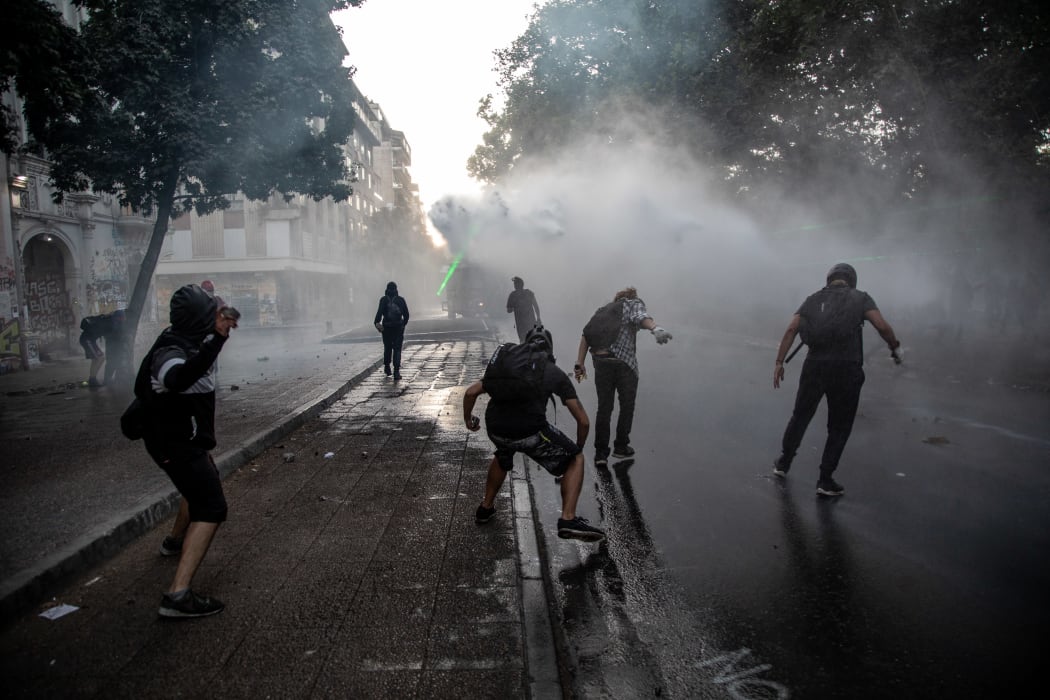 People protest against the economic policies of the government of President Sebastian Pinera and clash with riot polcie in Santiago, Chile.