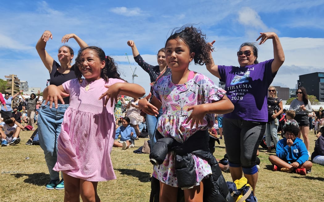 The crowd follows along with traditional Cook Islands dancing.
