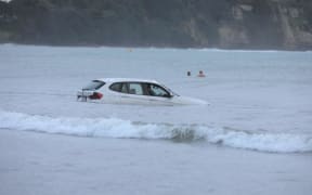 A car in the water at Stanmore Bay, Whangaparāoa Peninsula.